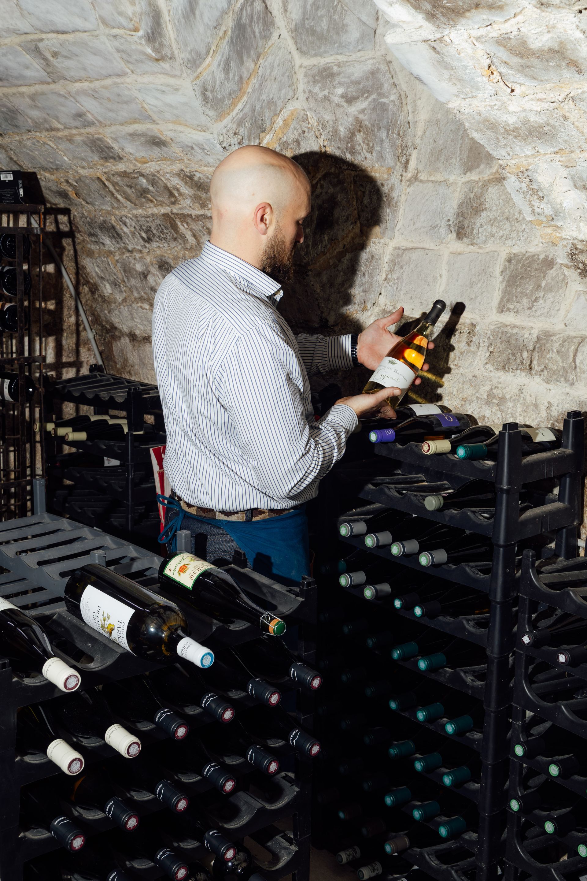 Alexandre sélectionnant des vins en cave