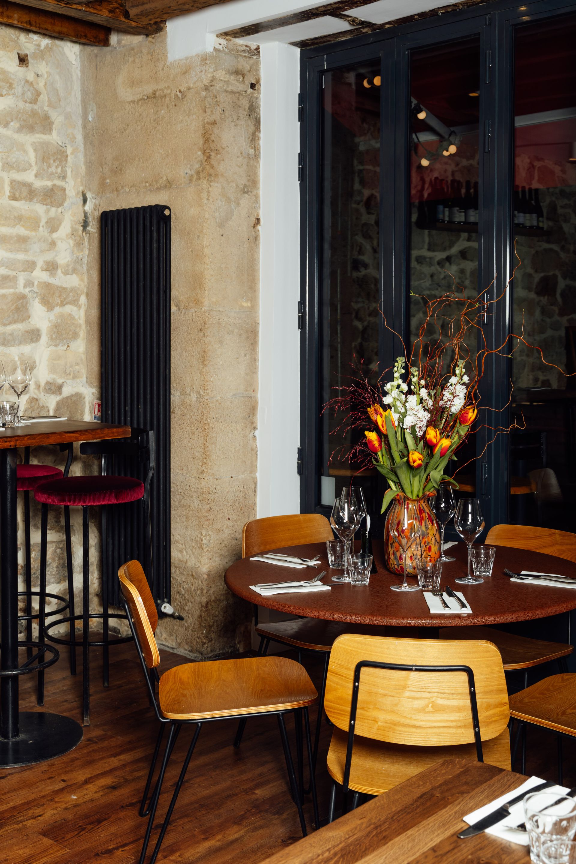 Table ronde avec tulipes, poutres et pierre