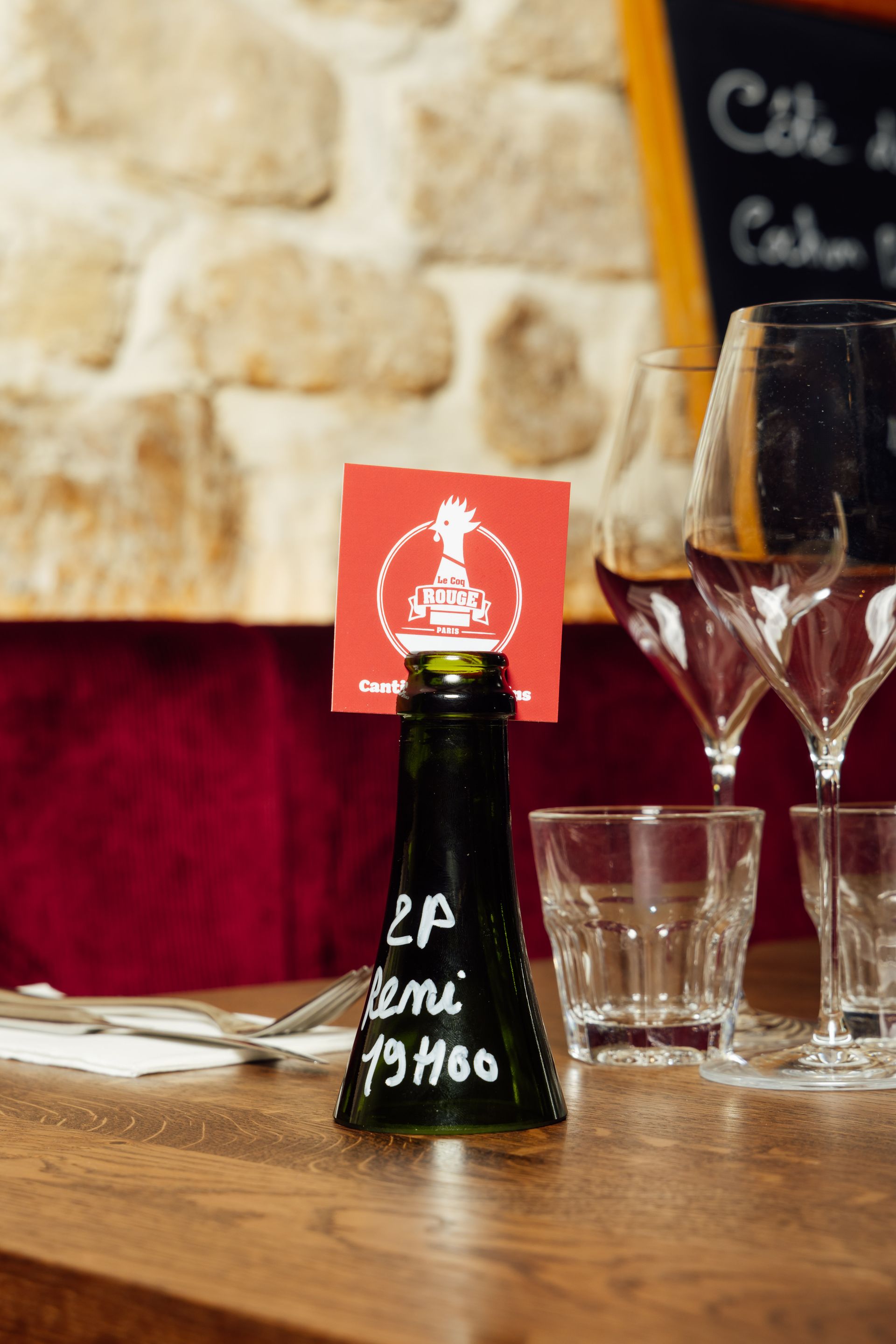 La carte du Coq Rouge glissée dans une bouteille